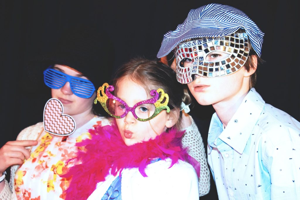 Kids posing inside a fun photo booth set up at a wedding reception. best dressed.